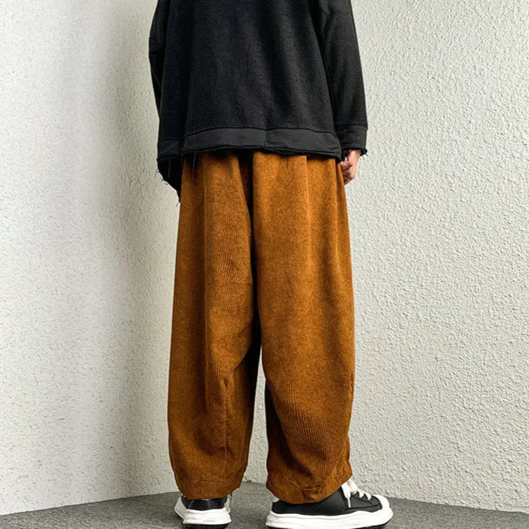 Stylish man wearing Arlo Corduroy Pants with a relaxed wide-leg fit in rich brown color, perfect for laid-back fashion.