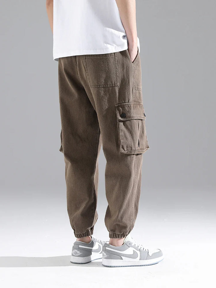 Lennox cargo joggers in heavyweight cotton blend with snap pockets and gathered cuffs, styled with a relaxed fit.