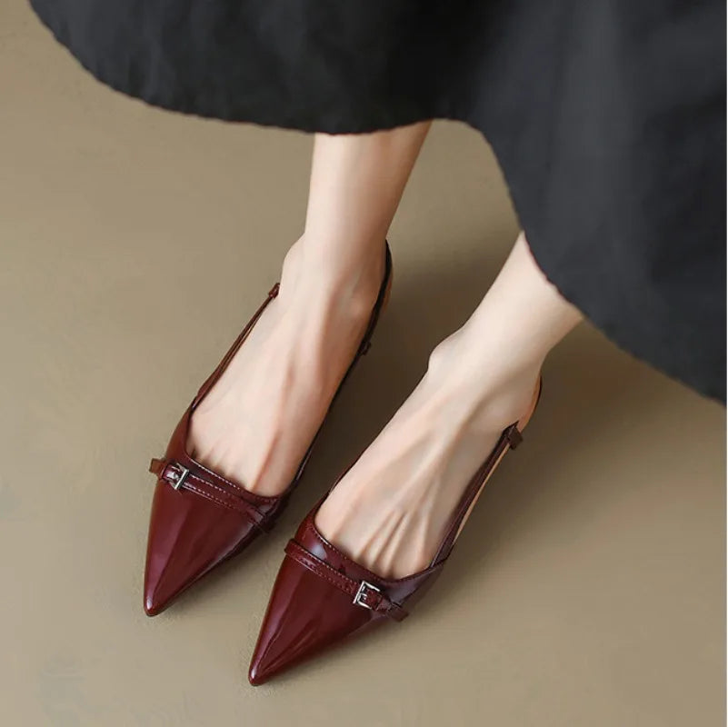 Sleek burgundy pointy-toe slingback heels with adjustable strap and shiny finish on a light background.