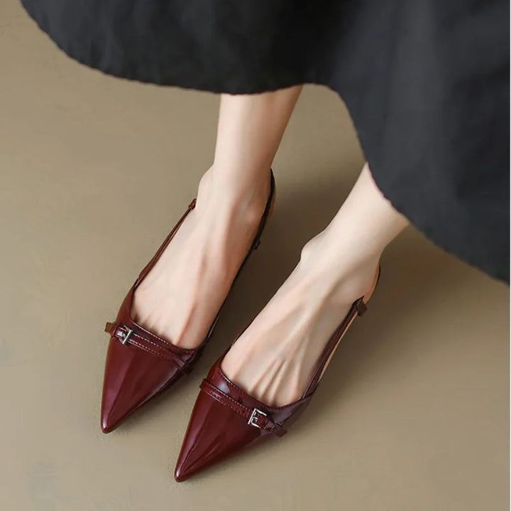 Sleek burgundy pointy-toe slingback heels with adjustable strap and shiny finish on a light background.