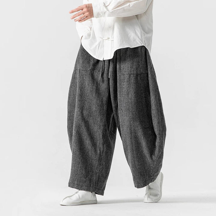 Henderson wide-leg corduroy pants with deep pleats and gathered elastic waistband, offering a relaxed yet structured fit.