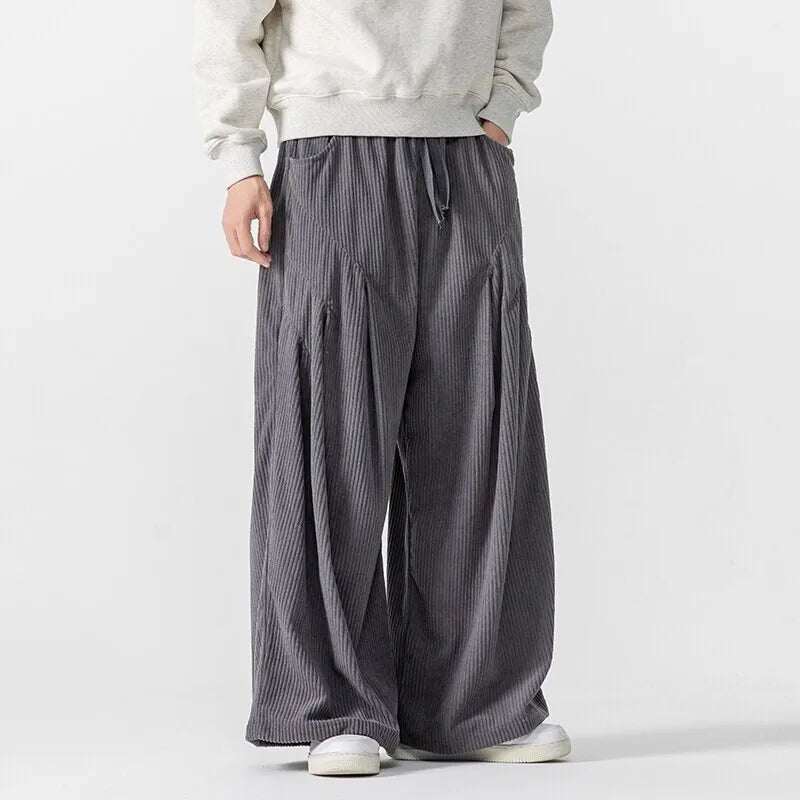 Hollis wide-leg corduroy pants with deep pleats and elastic waistband, styled for a bold, structured look.