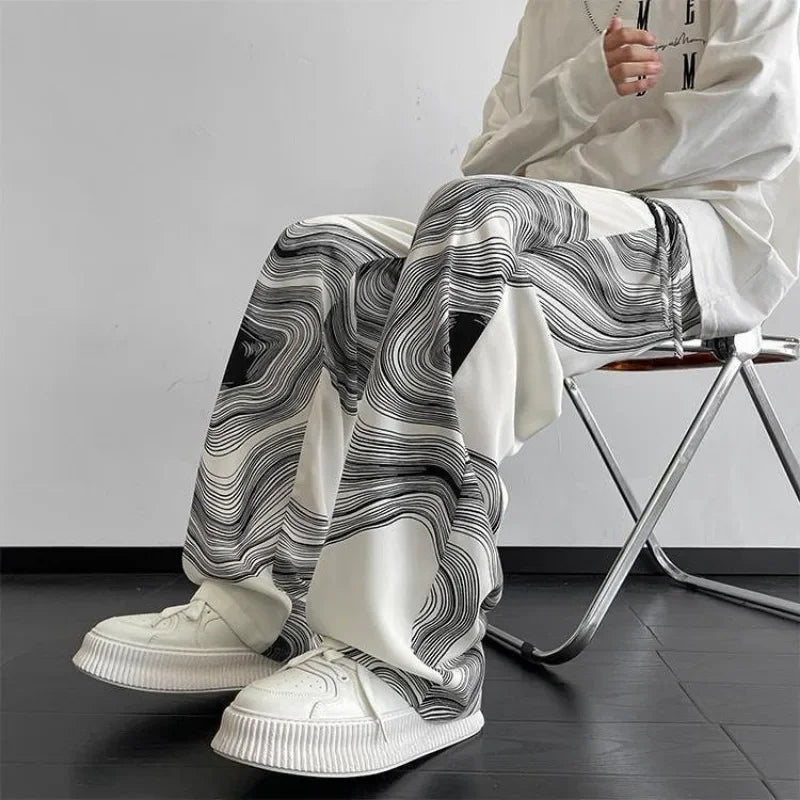 Vortex Ripple Pants featuring a hypnotic abstract print with wide-leg design and adjustable drawstring waist, styled with sneakers.