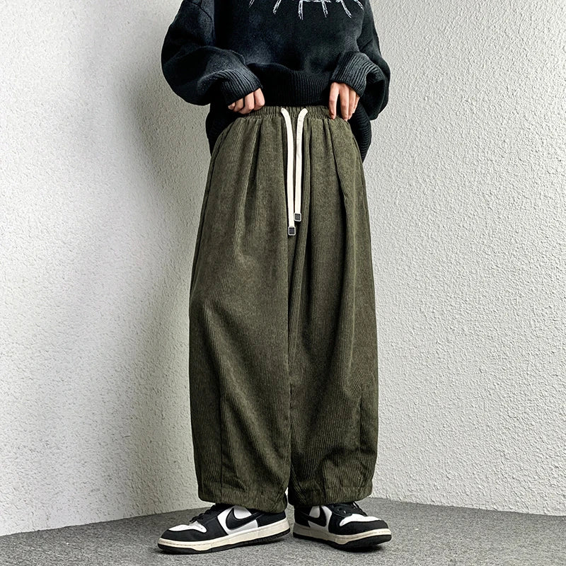 Model wearing Arlo corduroy pants with wide-leg fit, drawstring waist, and deep pockets for a stylish streetwear look.