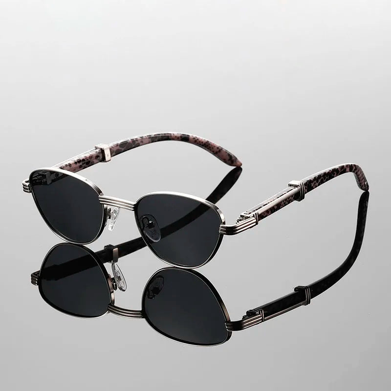 Sleek black sunglasses with silver frames and pink tortoiseshell arms, reflecting light in a stylish setting.