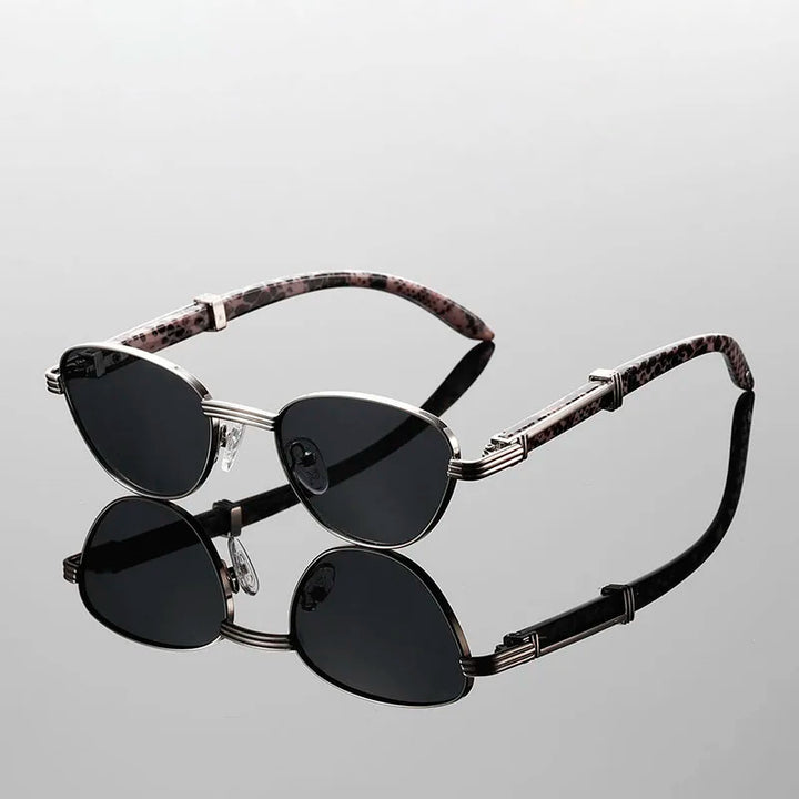 Sleek black sunglasses with silver frames and pink tortoiseshell arms, reflecting light in a stylish setting.