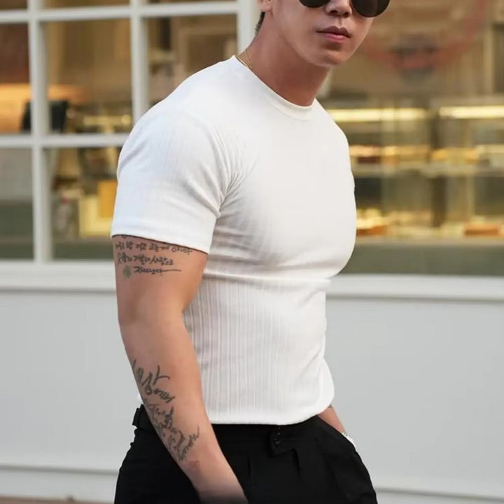 Man wearing a white ribbed knit flex-fit shirt, showcasing a tailored fit and stylish minimalism.