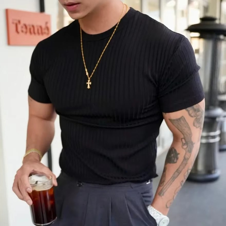 Man wearing a black Rowan Men's Flex-Fit Shirt with ribbed detailing, holding a drink, showcasing tailored fit.
