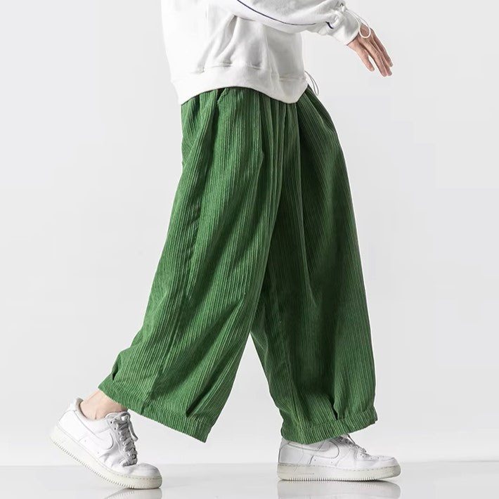 Green oversized corduroy pants with deep pleats, elastic waistband, and relaxed silhouette for effortless movement.